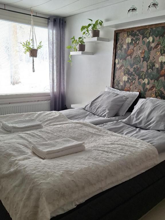 a bed with two towels on it in a bedroom at MarrasVilla in Marrasjärvi
