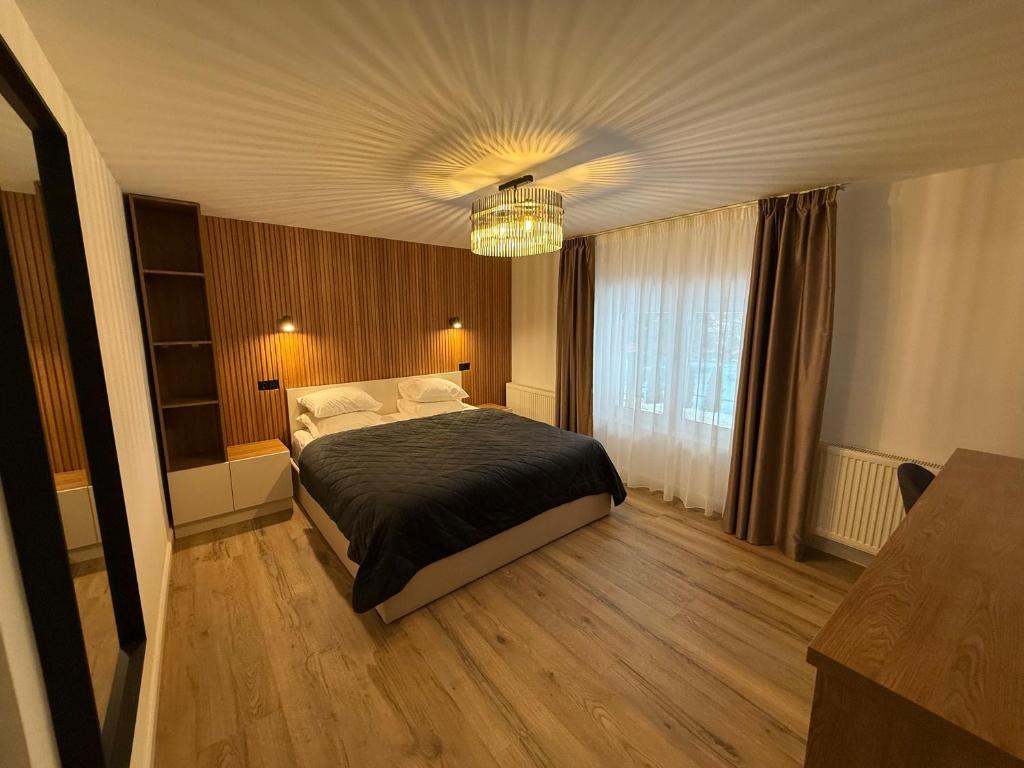 a bedroom with a bed and a chandelier at Shiro Lodge in Predeal