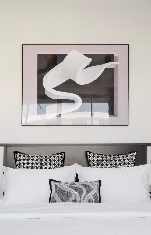 a bedroom with a white bed with a picture above it at CASA BLANCA Dusit in Dusit
