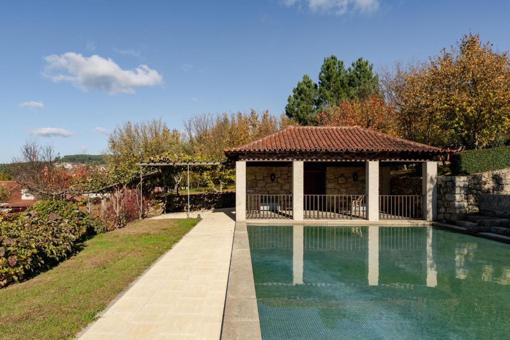 a swimming pool with a gazebo in a yard at Casas da Memória in Tarouca