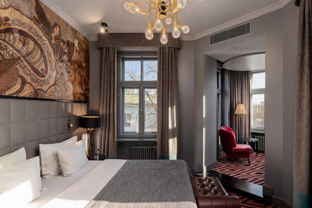 a hotel room with a bed and a chandelier at Grand Poet Hotel and SPA by Semarah in Riga
