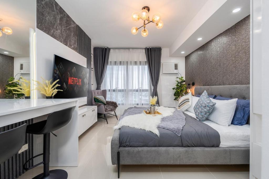a bedroom with a king sized bed and a desk at Layla by J&J At J Towers Residences It's just right next to SM JMall in Mandaue City