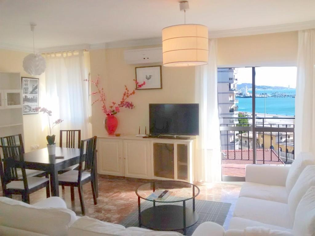 a living room with a white couch and a television at Malaga Soho in Málaga