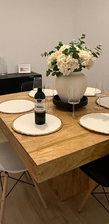 a table with a bottle of wine and a vase of flowers at Silver stays, calm coastal stay , close to beach in Gorleston-on-Sea