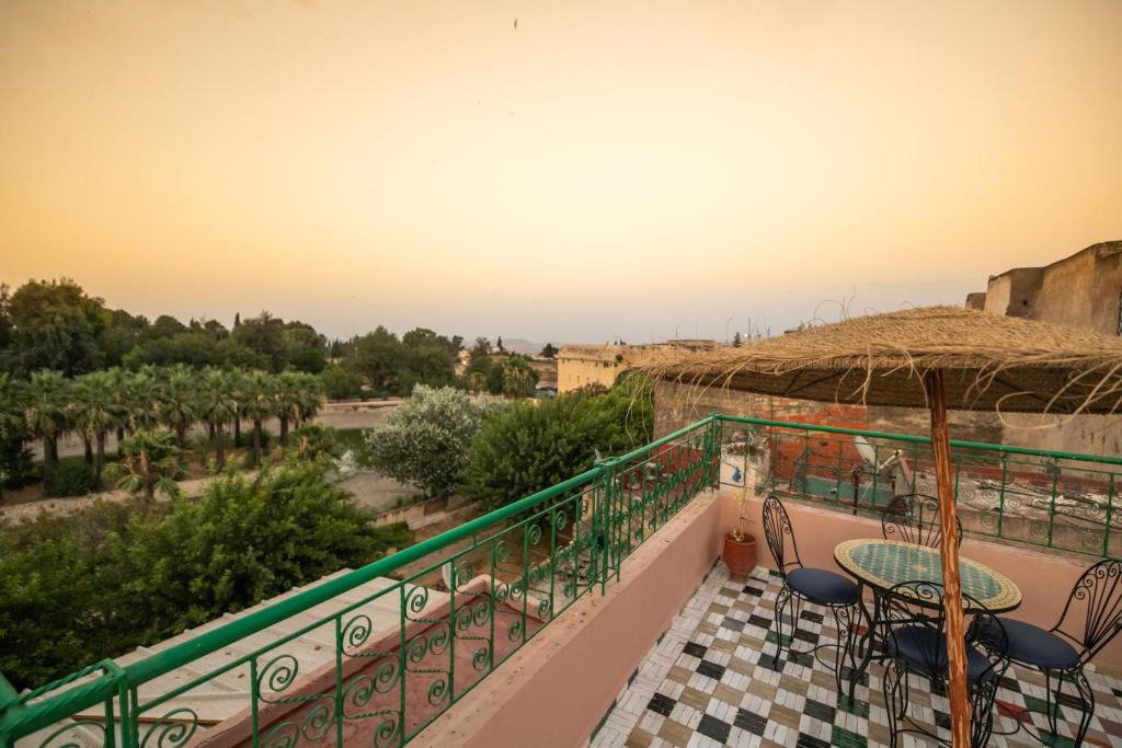 a balcony with a table and chairs and a view at Guest House Jnan Sbil in Fez