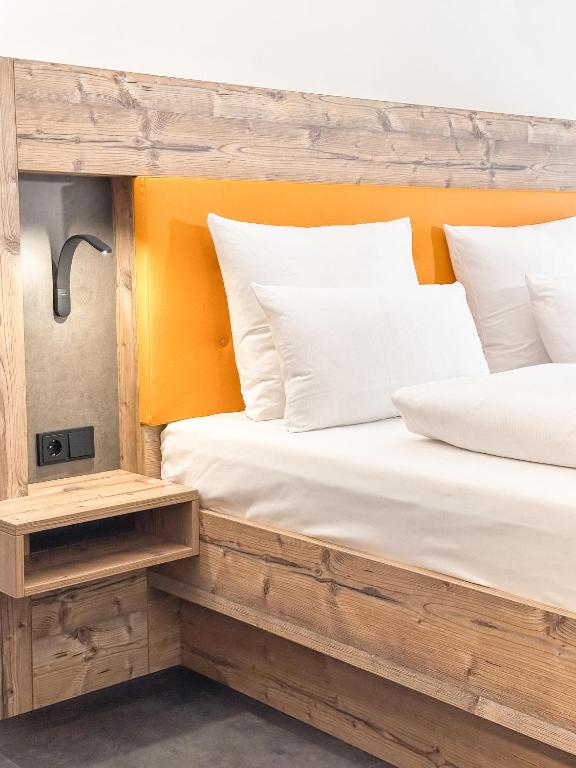 two beds with white pillows in a room at THE GOOD ONE Hotel Landshut in Landshut