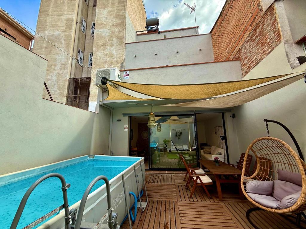 a balcony with a swimming pool and a table and chairs at CASA EN EL CENTRO DE CALELLA A 300 m DE LA PLAYA in Calella