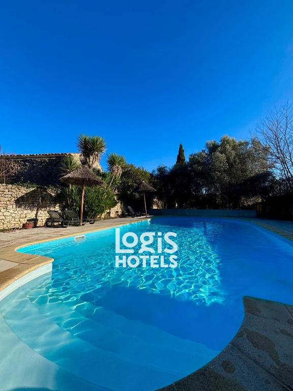 a blue swimming pool with the words los hotels at Logis Hotel Restaurant L'Esquielle in Saint-Géniès-de-Malgoirès