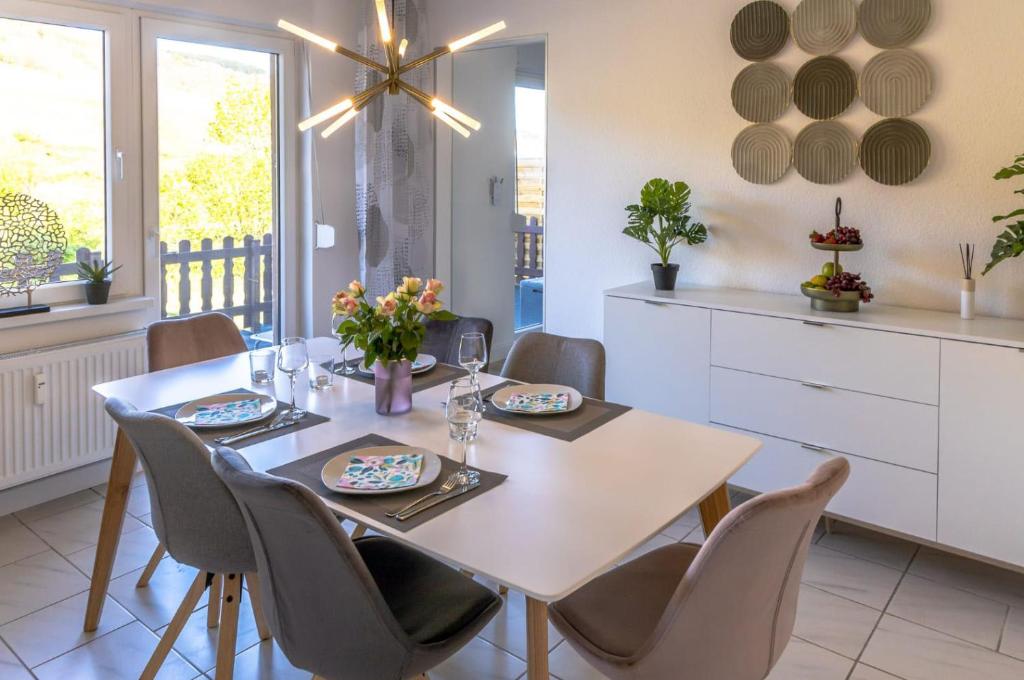 a dining room with a white table and chairs at Moselgoldt in Burg