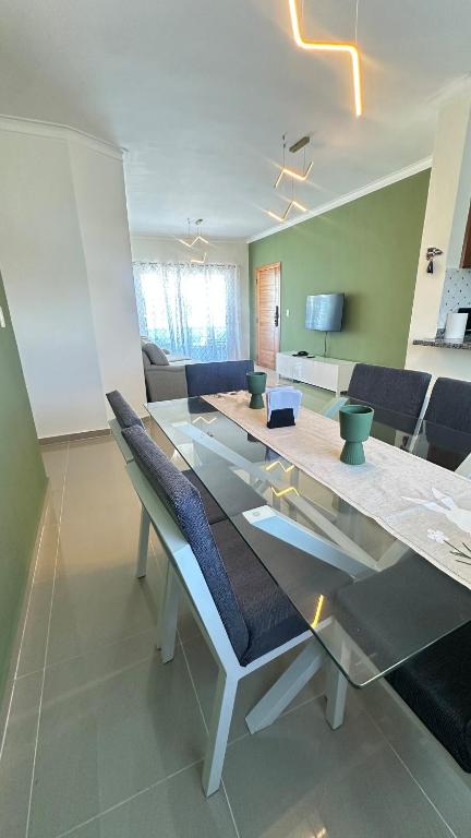a living room with a glass table and chairs at Green House Boca Chica in El Higo
