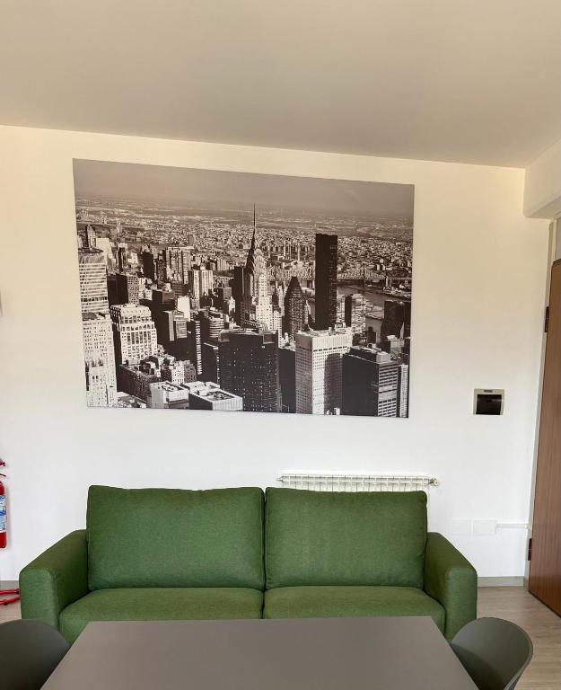 a green couch in a room with a picture of a city at La Casa Di Elda in Terni