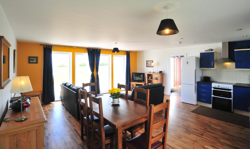 a kitchen and living room with a wooden table and chairs at Hartaval & Baca Ruadh in Staffin