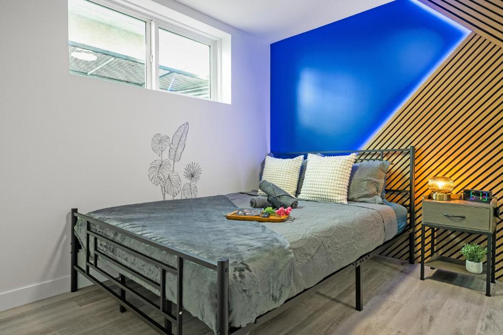 a bedroom with a bed with a blue wall at Cosmic Game Room, Yard & Close to WEM in Spruce Grove
