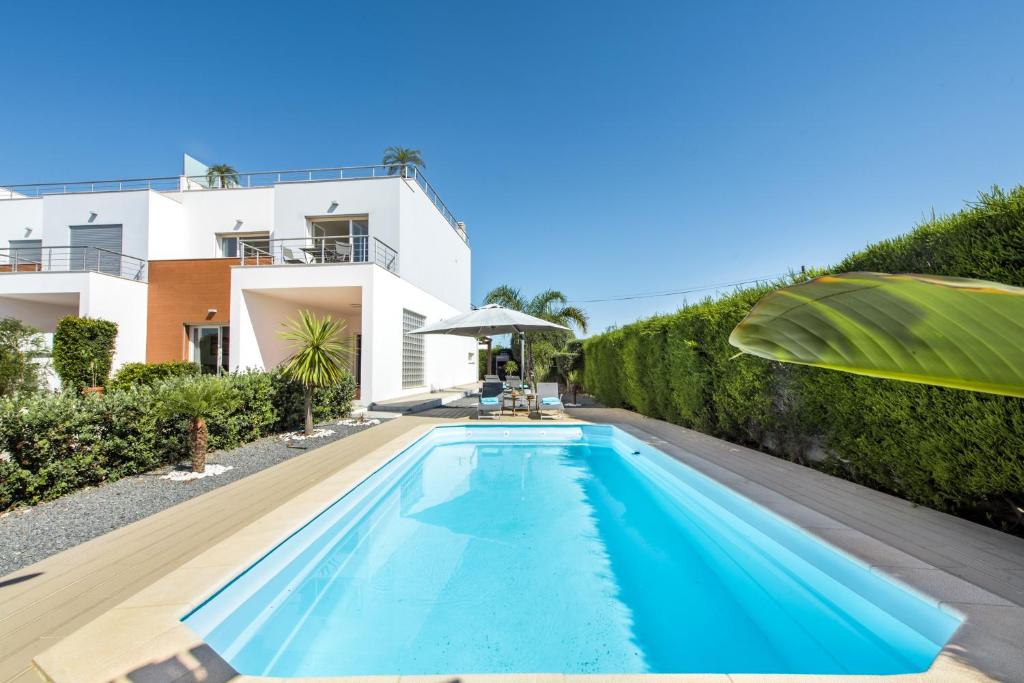 a swimming pool in front of a house at Casa Jacadi Luxury Villa, Private Pool, Rooftop terrace with sea View! in Armação de Pêra