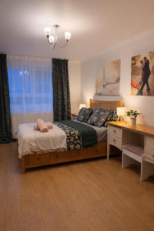 a bedroom with a bed and a desk and a window at Sutton Cosy Rooms in Sutton