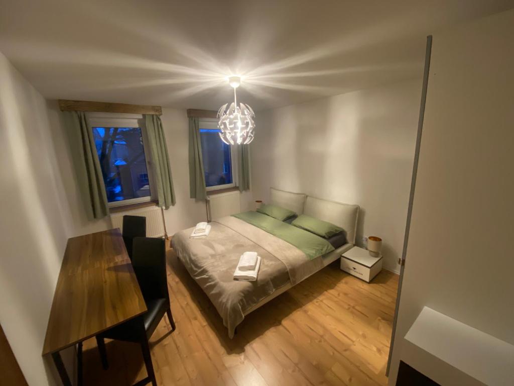a bedroom with a bed and a table and a chandelier at Wunderhaus am Goitzschesee in Bitterfeld