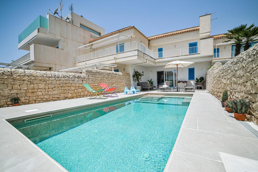 a swimming pool in front of a house at Villa Gioia con piscina privata in Marina di Ragusa
