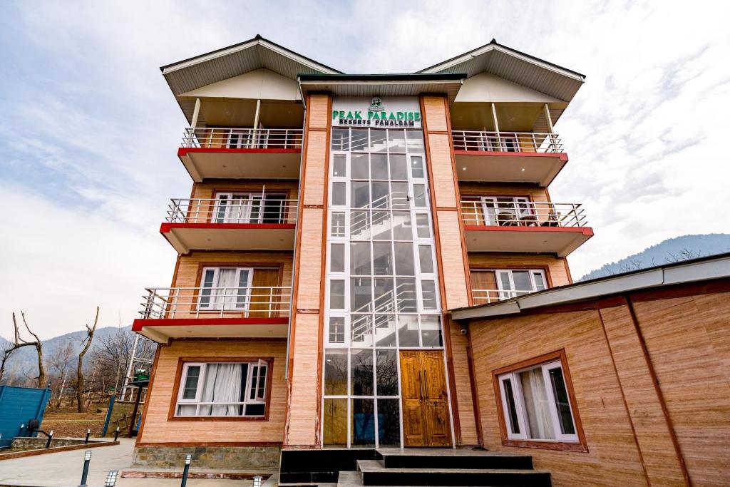 a tall building with a glass facade at Hotel Peak Paradise Resorts in Pahalgām