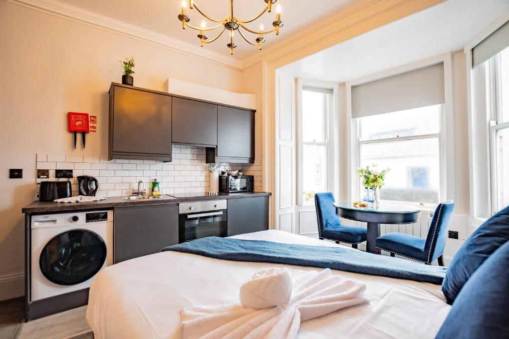a bedroom with a bed and a table and a kitchen at Marina View Studio - Harbour in Dublin