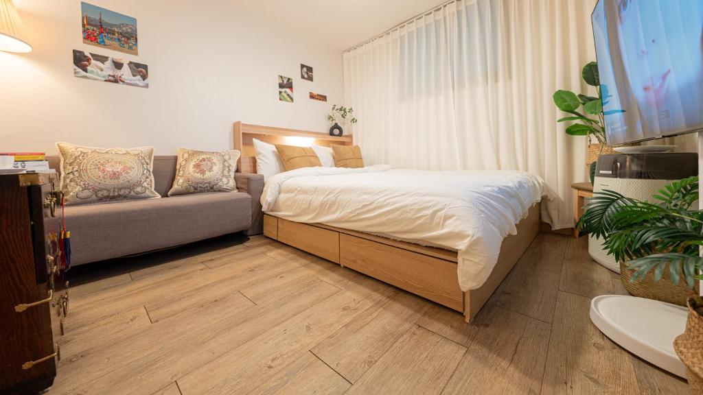 a bedroom with a bed and a couch at STR Stay Bangbae in Seoul