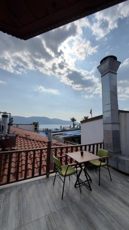 a patio with a table and chairs on a roof at Sarıyer Otel in Ula