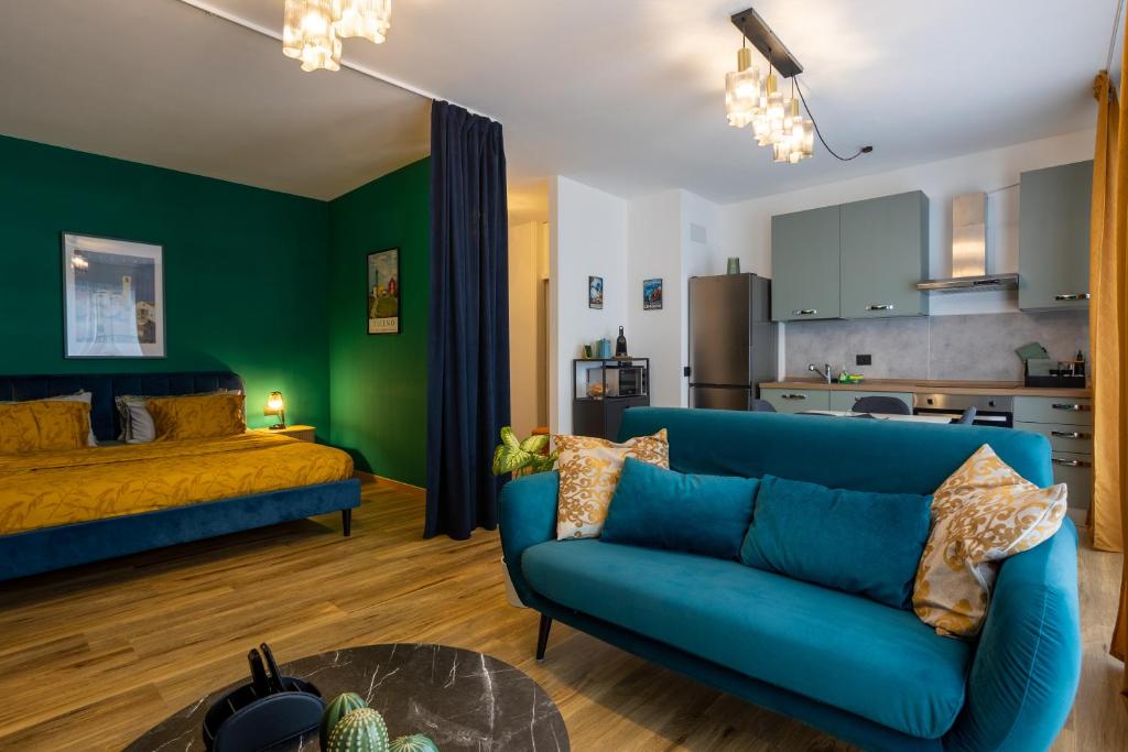a living room with a blue couch and a bedroom at Lakeside Lugano in Lugano