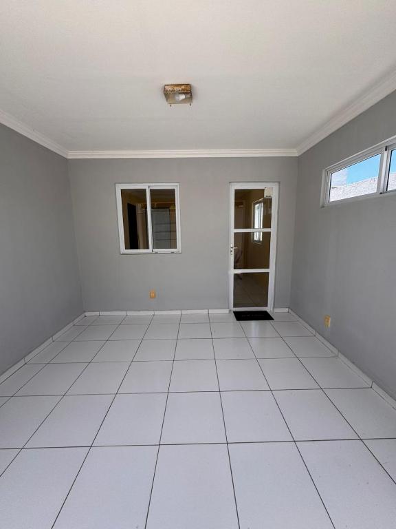 an empty room with white tile floors and a window at Casa Freire in Maceió