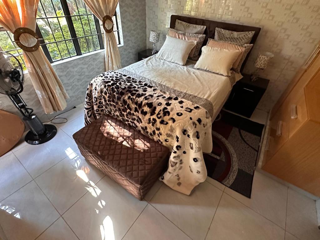 a bedroom with a bed with a leopard print comforter at Cactus Village in Blantyre
