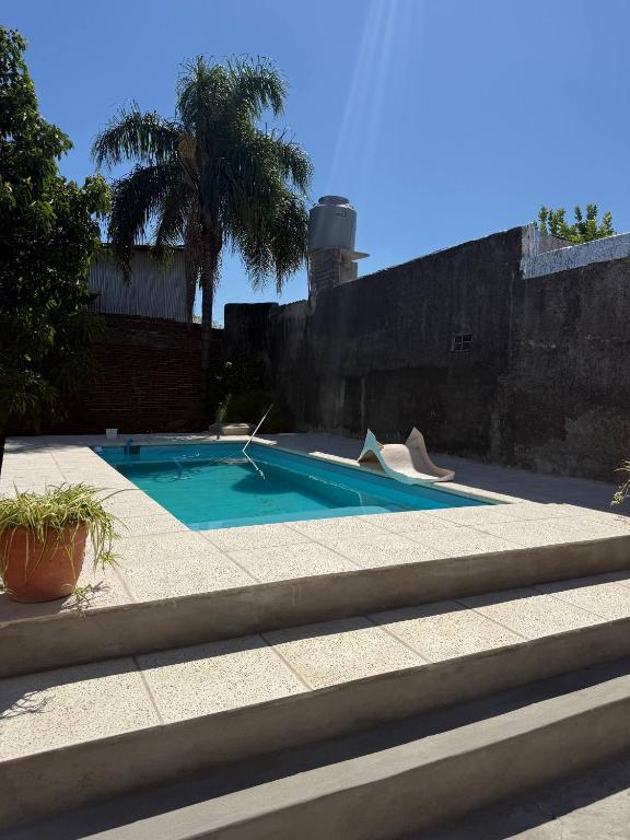 a swimming pool in a yard next to a wall at Casa 2 hab, cerca del centro y costanera in Gualeguaychú