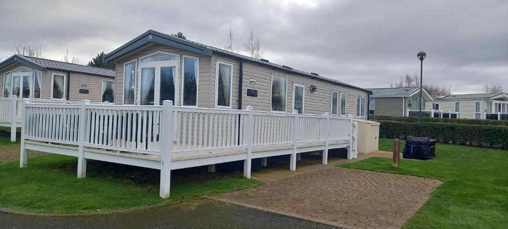 a house with a white porch and a white fence at Chill Out in the Golf Village at Seton Sands in Port Seton