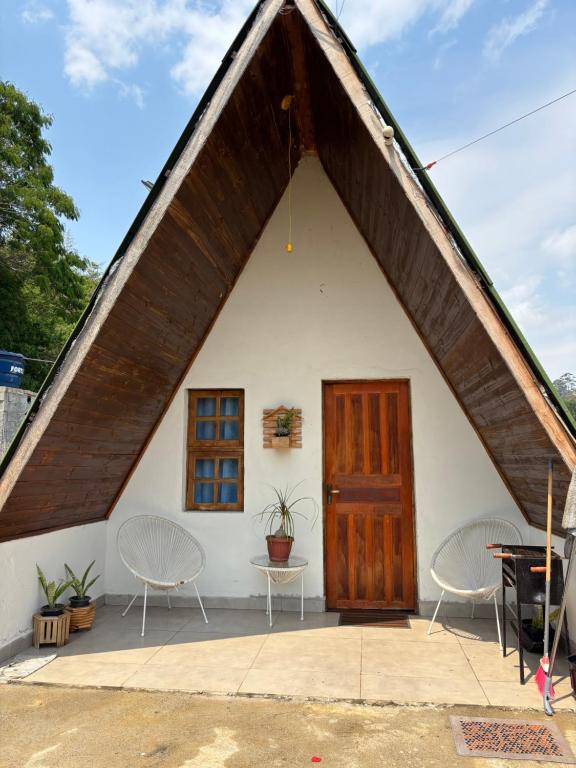 a small white house with a large wooden door at Elshadaychale in Ibiúna