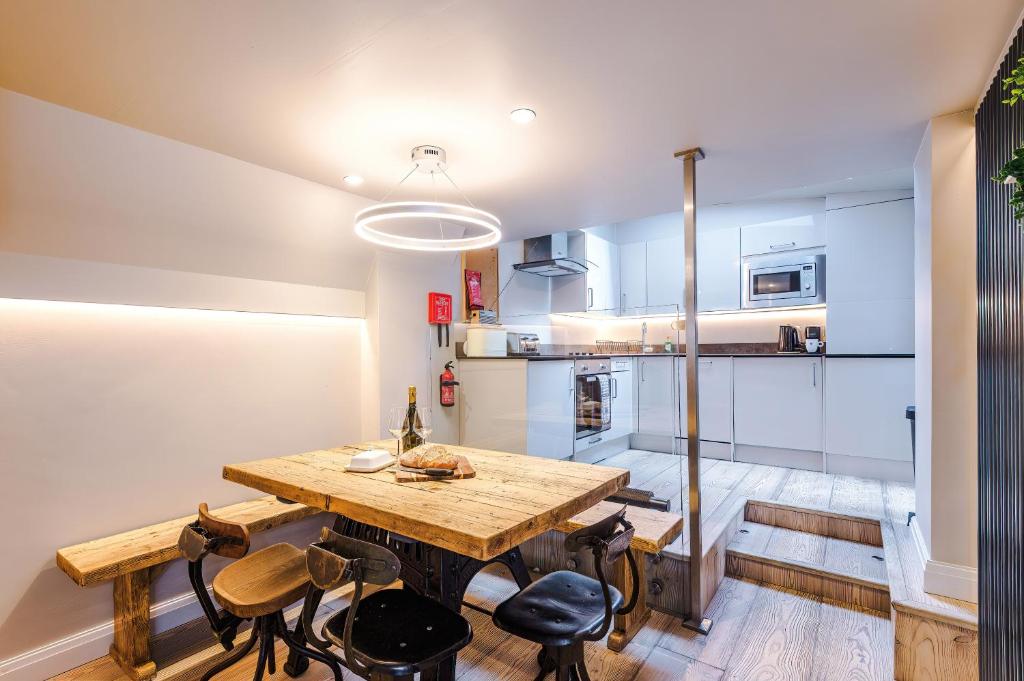 a kitchen and dining room with a wooden table and chairs at Cosy Lake District Cottage - Walk to Windermere - Sleeps 6 in Windermere