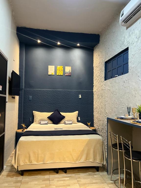 a bedroom with a bed with a blue wall at Pousada É de casa unidade 02 apto 01 in Juazeiro do Norte