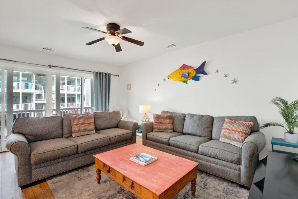 a living room with two couches and a ceiling fan at Tybee Turtle in Tybee Island