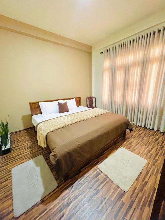 a bedroom with a bed and a window with rugs at Yemi Bungalow Ella in Ella