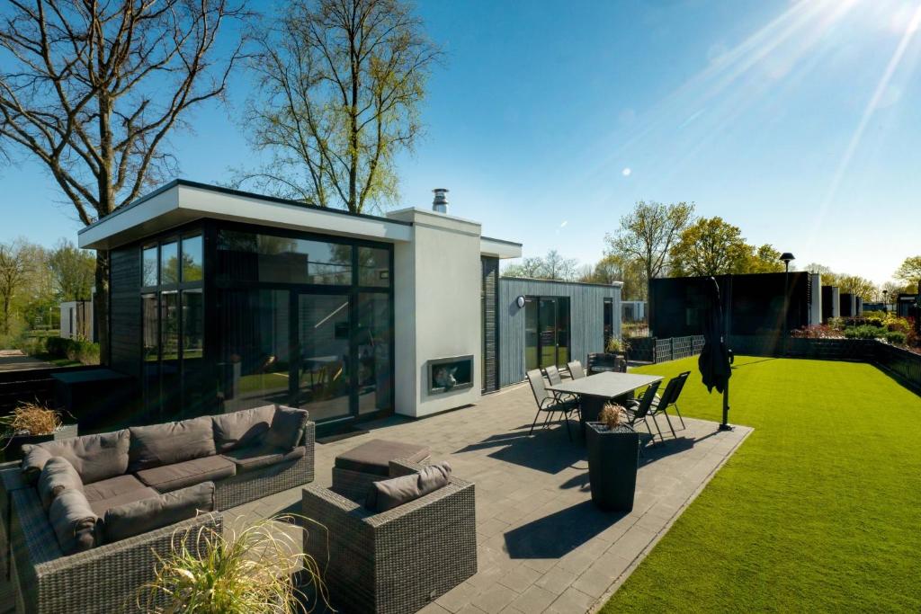 a patio with a couch and a table in a yard at Veluwemeer Retreat in Hulshorst