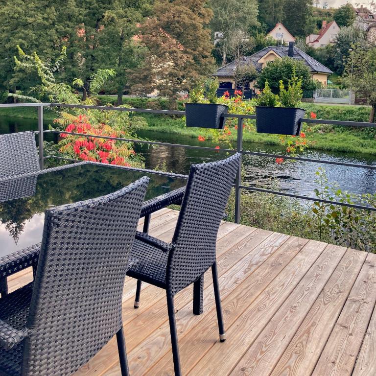 two chairs sitting on a deck with a view of a garden at Otava apartments - Rezidence Valcha in Sušice