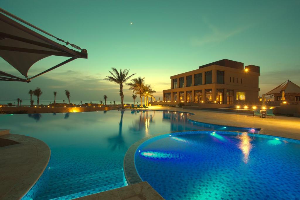 a large swimming pool in front of a building at Royal L'azure Resort in Sharmaa