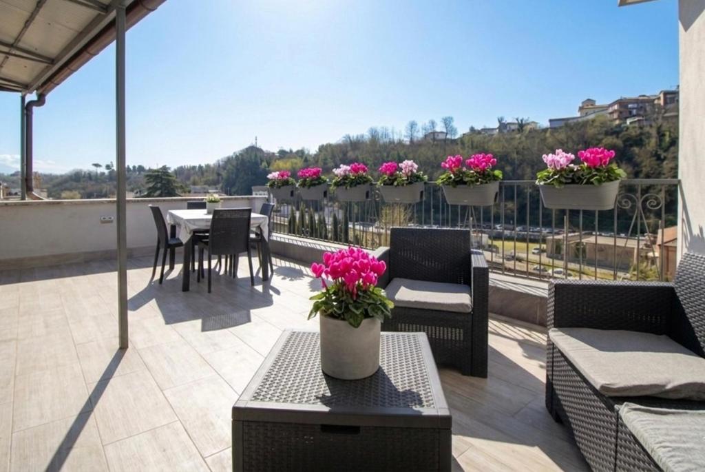 a patio with tables and chairs and flowers on a balcony at Raggio di Sole Suite in Valmontone