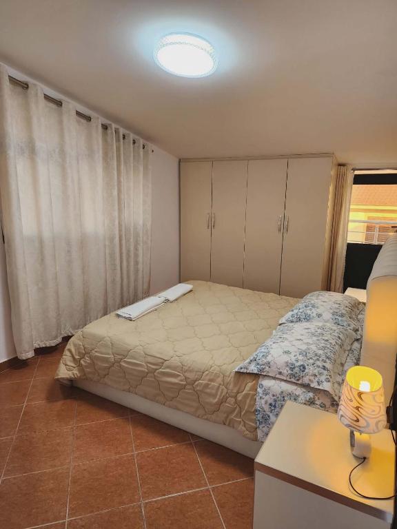 a bedroom with a large bed and a table at Apartment 3 by Villa Ceni in Elbasan