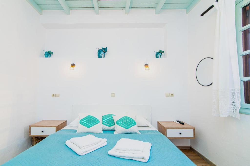 a bedroom with a bed with blue sheets and pillows at Alegria Pension in Chania