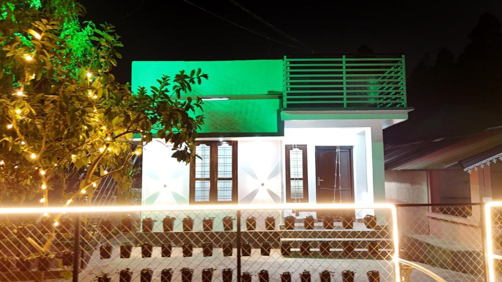a white house with a green sign on top of it at Couples Nest in Kottakamboor