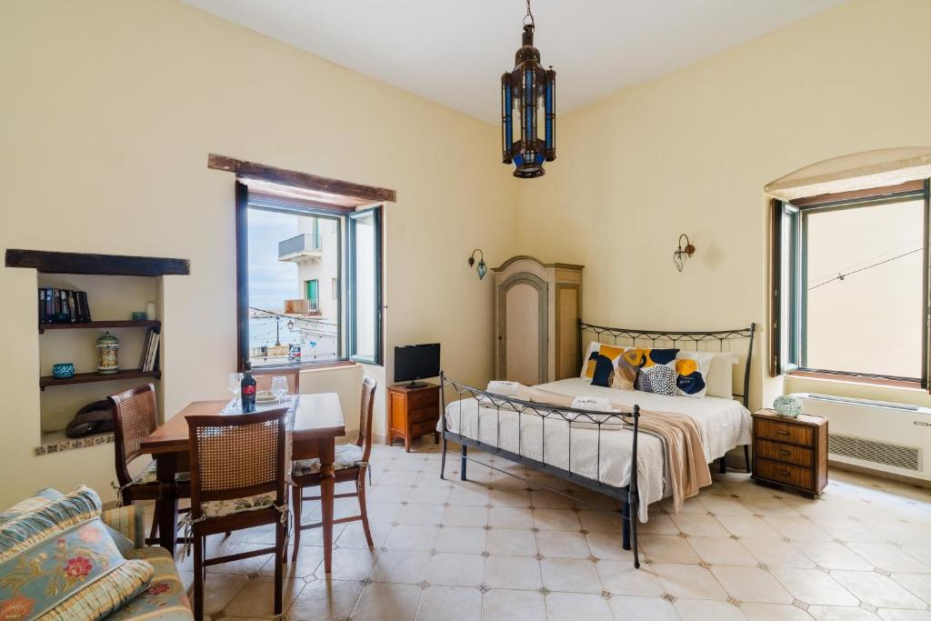 a bedroom with a bed and a table and chairs at Mono Scilla Centro Storico Otranto in Otranto