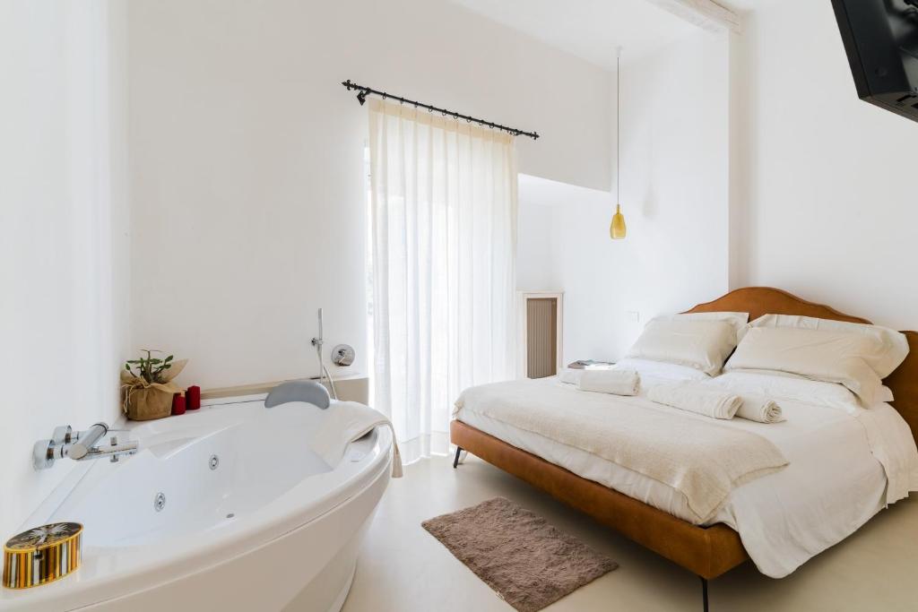 a bedroom with a large bed and a bath tub at Bacchus Historic Home in Otranto