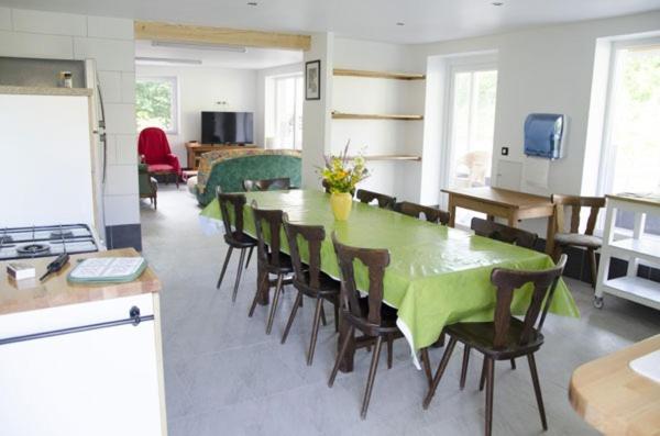 a dining room with a green table and chairs at Gîte Le Charme in Aspach-le-Bas