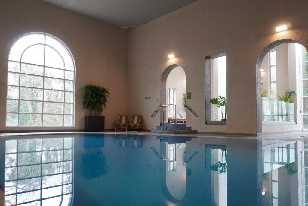 a large swimming pool in a room with windows at Twin Trees Hotel & Brusna Falls Leisure in Ballina