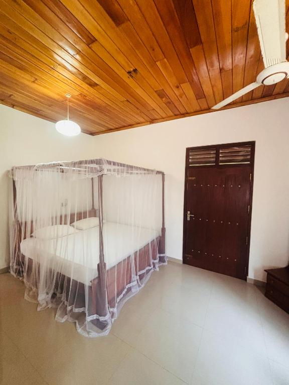 a bed in a room with a wooden ceiling at Hiru Villa in Bentota