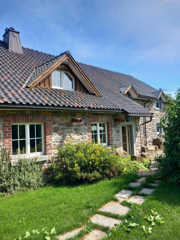 a house with a tile roof on top of a yard at Fermette Lejoly in Waimes
