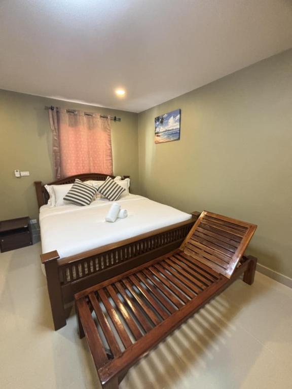 a bedroom with a large bed with white sheets at Son House in Ban Thalat Choeng Thale