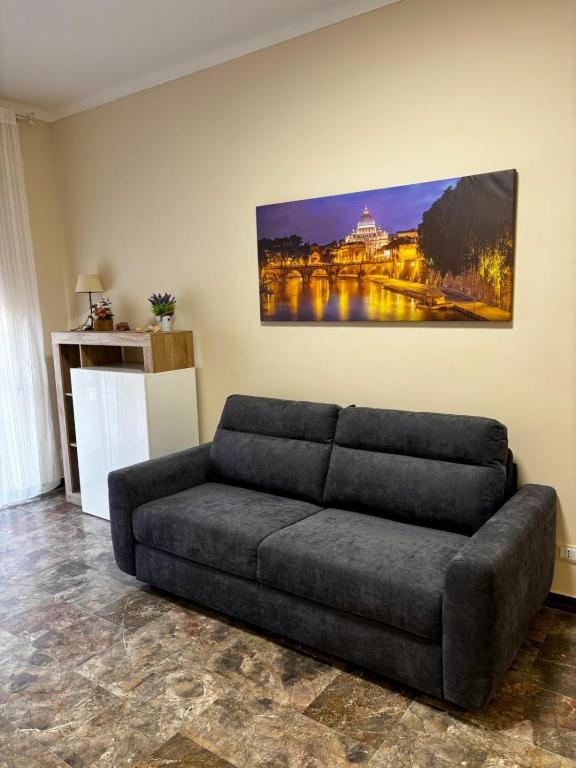 a couch in a living room with a painting on the wall at Grazioso Appartamento Ostia Roma in Lido di Ostia
